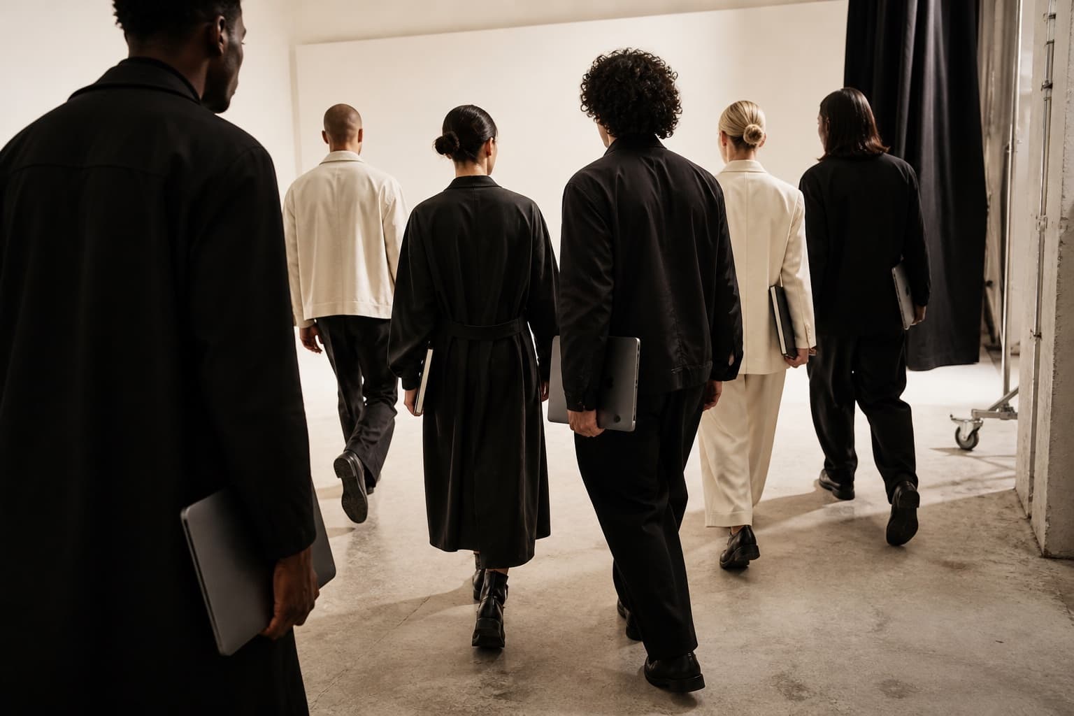 A symbolic six-person team walking through a white studio